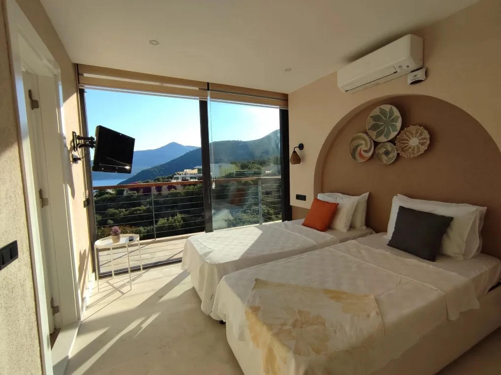 Kemerli başlıklı, deniz manzaralı süit yatak odası