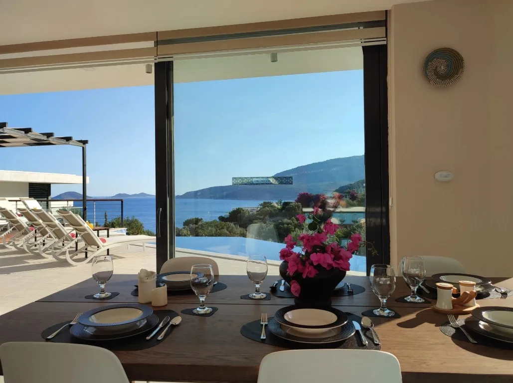 Pergola terasta hazırlanmış akşam yemeği sofrası ve deniz